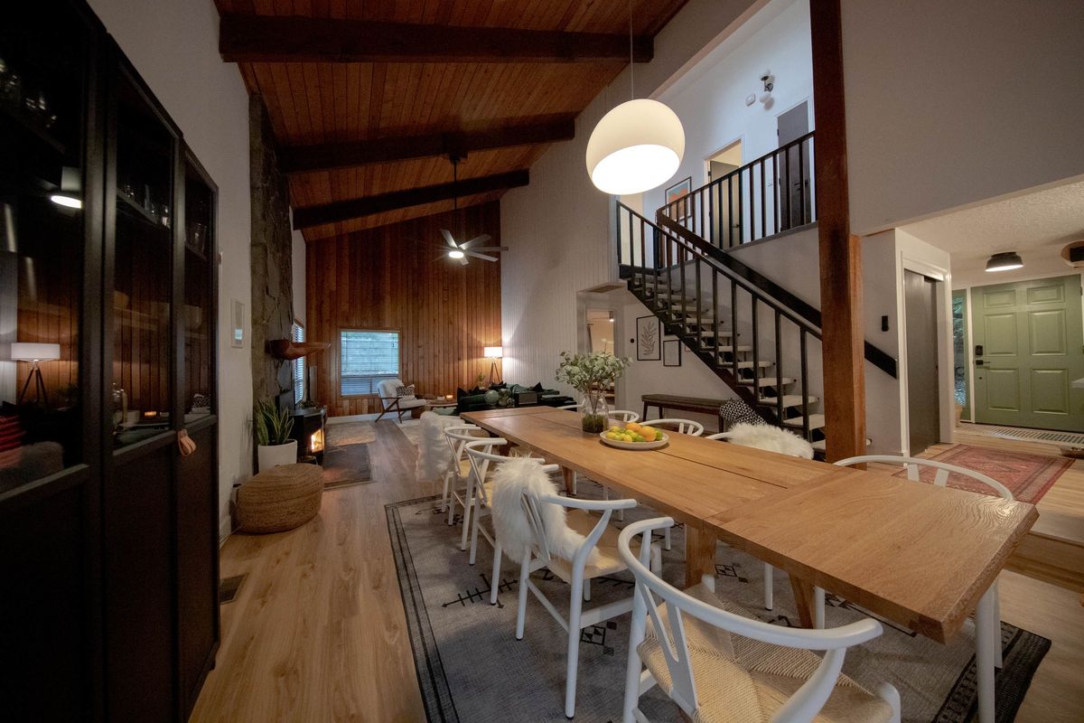 Great room with dining table, open stairs and vaulted ceiling